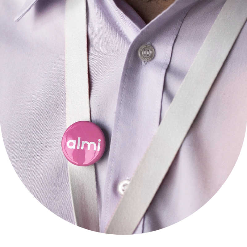 Rosa Almi-pin på axelrem över ljusrosa skjorta