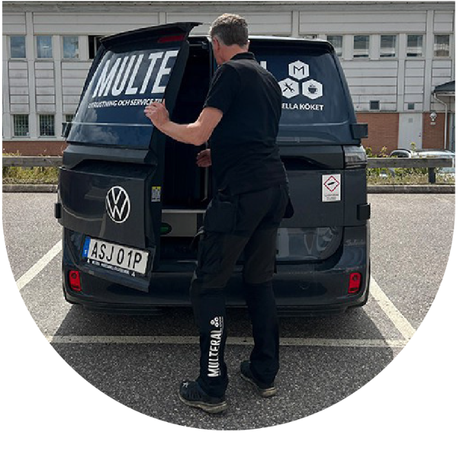 Multeral-anställd i uniform öppnar bakluckan på en svart bil med Multeral-logga